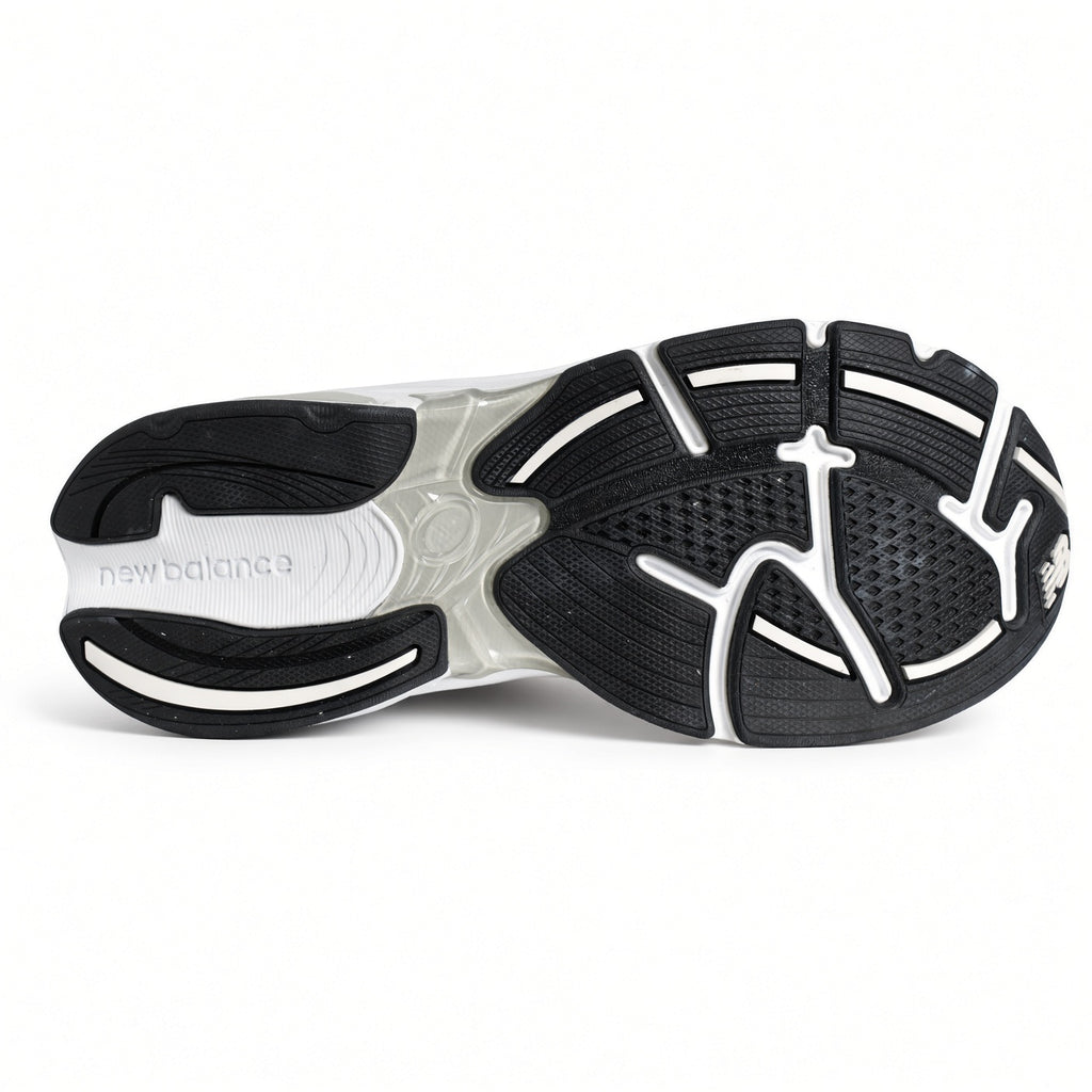 Close up view of the back heel cage and rubber outsole tread pattern on the New Balance 2010 grade school G201038W.