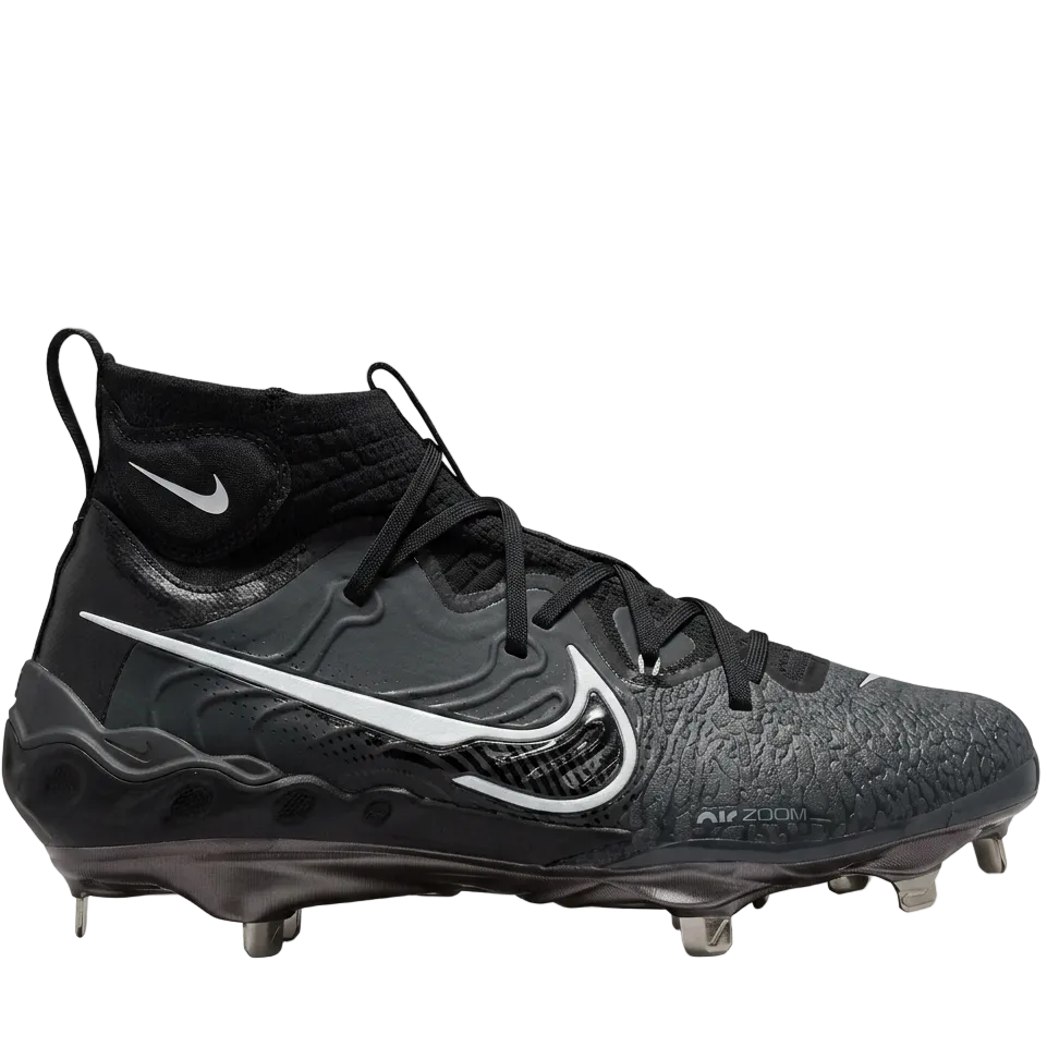 Side profile of Nike Alpha Huarache NXT baseball cleats in Black and Dark Smoke Grey with metal spikes